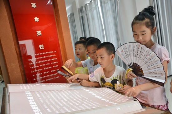 孩子们在翻阅电子书 了解抗战事迹 