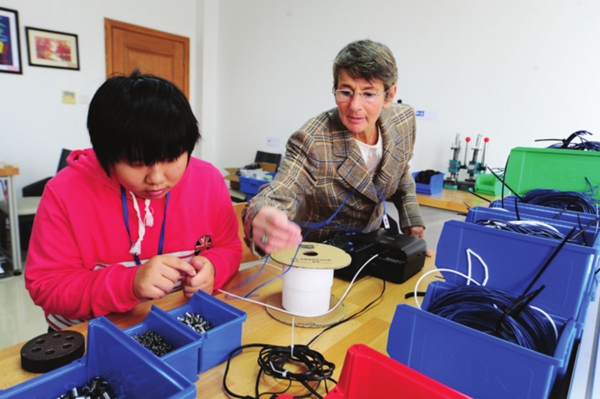 德国培训师维罗妮卡向残疾员工讲解技术操作步骤