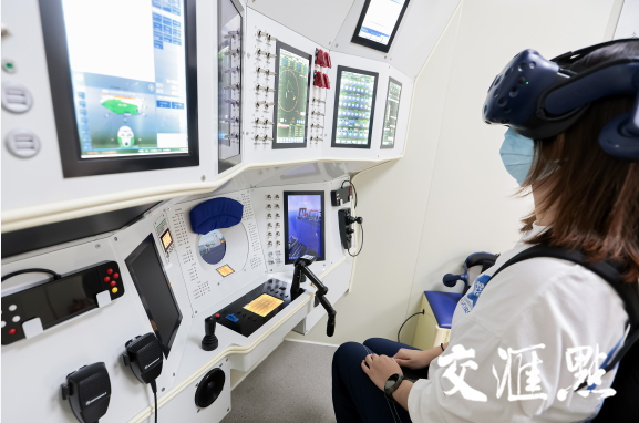 图为观众戴VR眼镜在“奋斗者”号内部体验“海底遨游”。