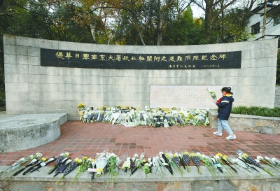 南京大屠杀死难者国家公祭仪式今天举行。12月12日，南京市民在侵华日军南京大屠杀北极阁附近遇难同胞纪念碑前悼念遇难同胞。 南京日报/紫金山新闻记者 徐琦 摄