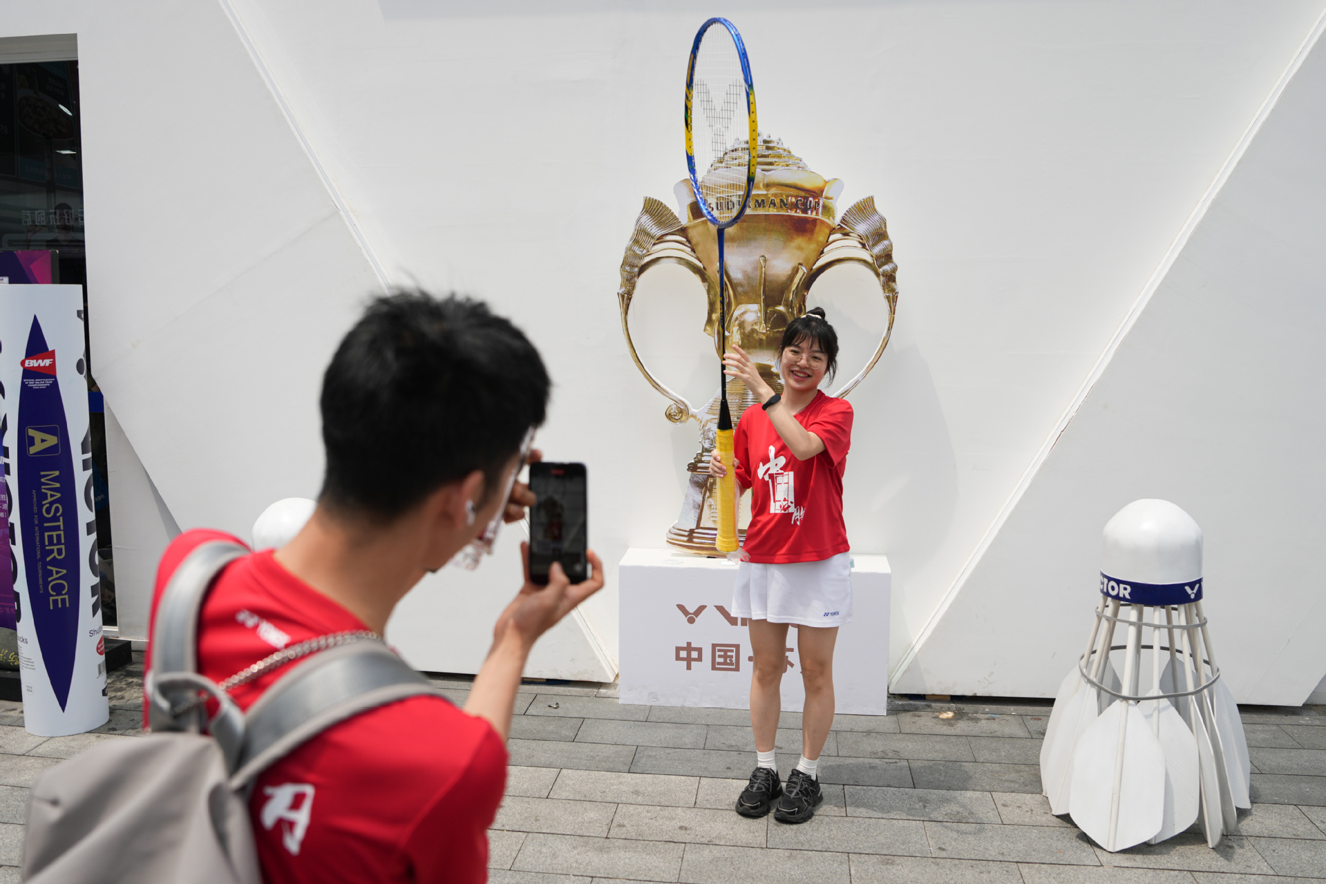 苏杯赛场外，球迷们在展区中身着中国队加油服装打卡拍照  新华社发