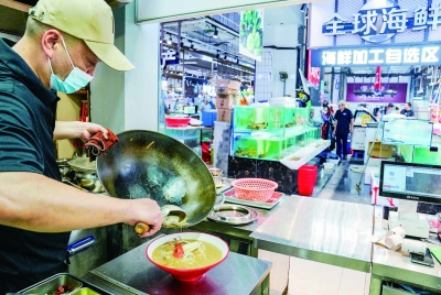 在位于江宁区通淮街的“刘姐菜篮子”太平店,消费者在海鲜加工自选区选购食材后,厨师现场加工烧制菜品。 南京日报/紫金山新闻记者 戚珂嘉 摄
